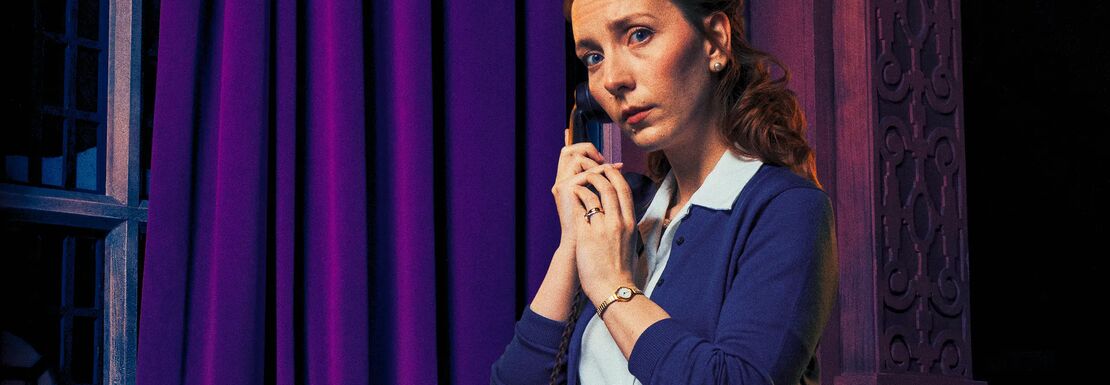 Woman with navy blue cardigan on the phone