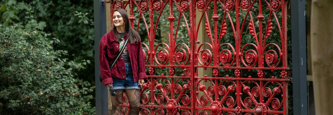 Woman smiling at the red gate at Strawberry Field