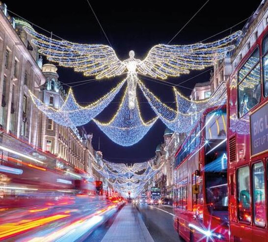 London buses going down a busy London street with Christmas lights