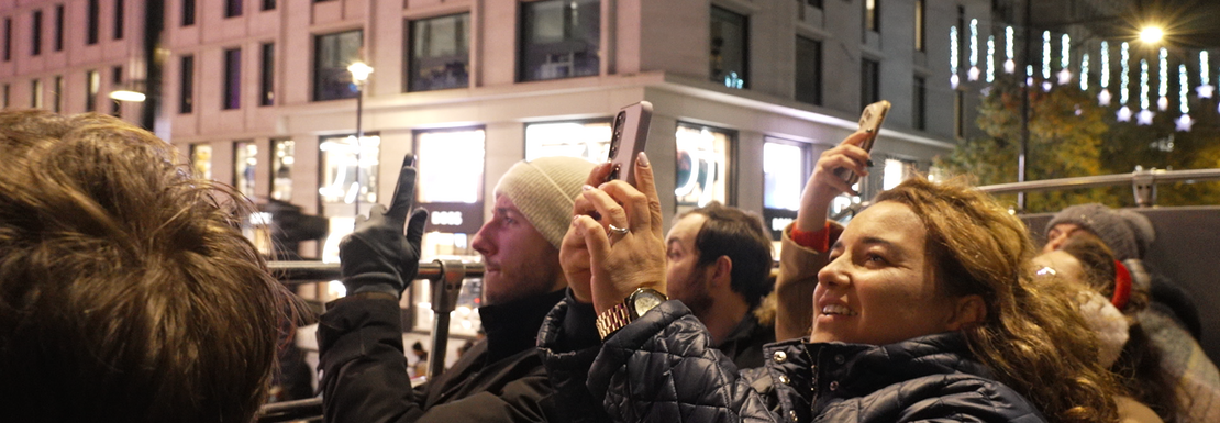 Tourists take photos of Christmas lights from a tour bus