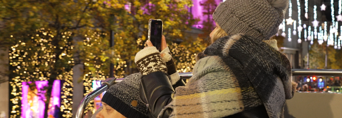 Tourists take photos of Christmas lights from a tour bus