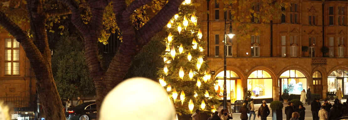 Tourists looking out at Christmas lights from a tour bus