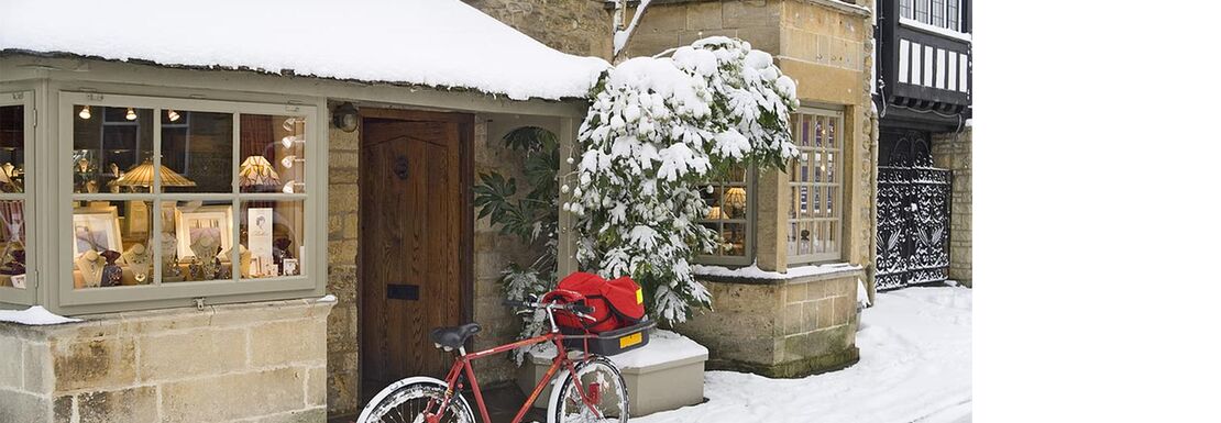 A snowy English village scene with a bicycle