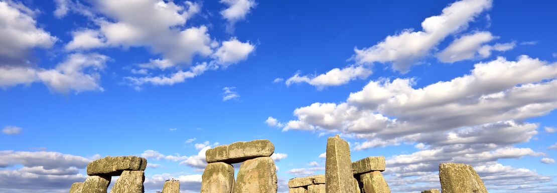The full Stonehenge stone circle on a blue sky day