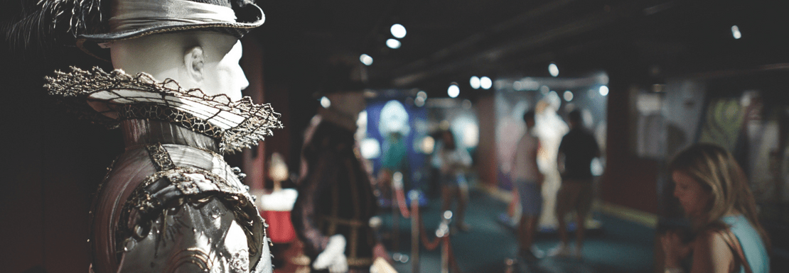 A visitor looking at costumes at the Globe Theatre