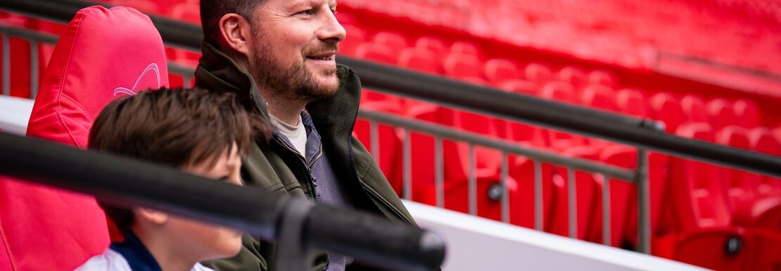 A father and son sitting in the stands at Wembley Stadium