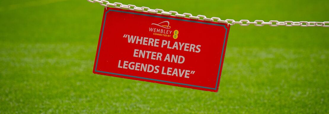 A sign on the pitch stating "Where players enter and legends leave"