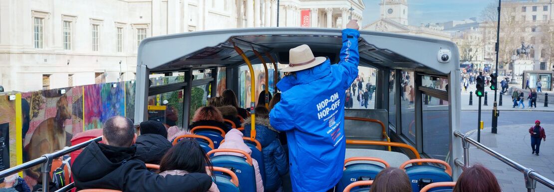 Guide talking visitors on a open bus