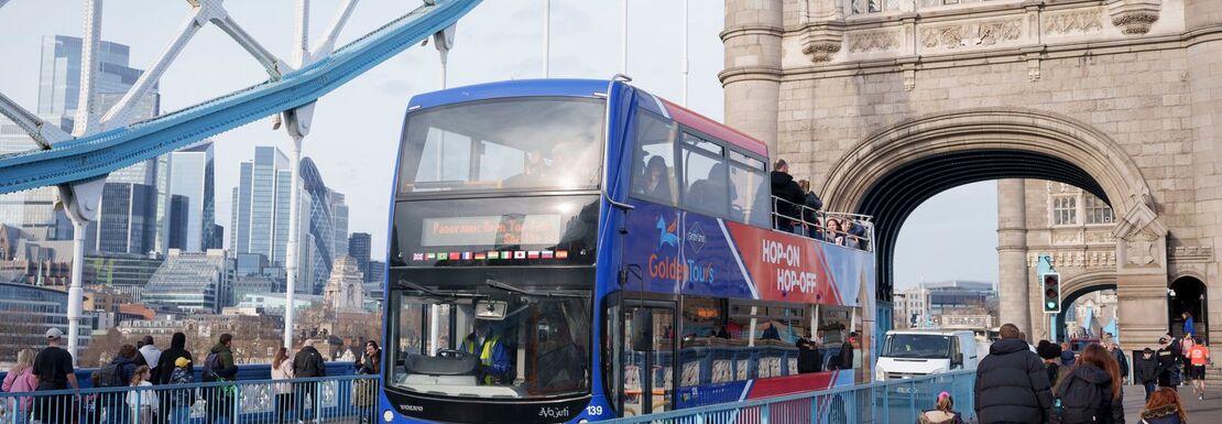 Blue and red open bus on Tower Bridge