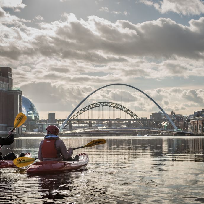 Couple kayaking on a river under blue skies