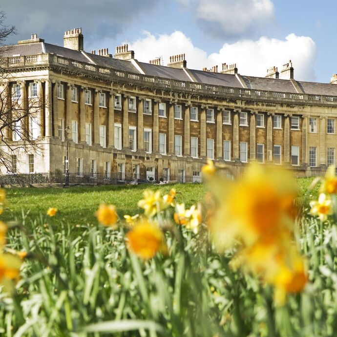 External view of regency style curved row of buildings with a field of blurred out daffodils in the foreground