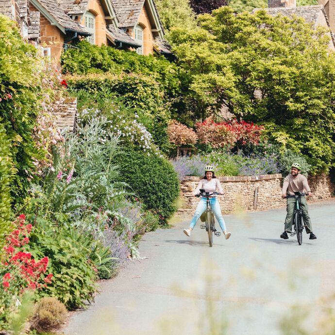 A couple cycling through the Cotswolds